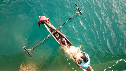 small children fishing in small boats. fisherman boy looking for fish.