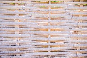Texture and background of twig weaves. Woven bamboo fence with seamless pattern. Handmade work.