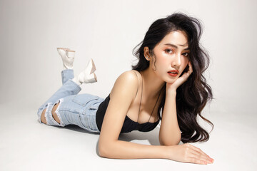 Street fashion Slender figure, beautiful face, graceful woman lying on the floor on isolated white...