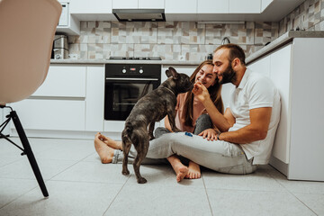 Cheerful Woman and Man Having Fun Time at the Kitchen with Their Dog, French Bulldog with Family at Home
