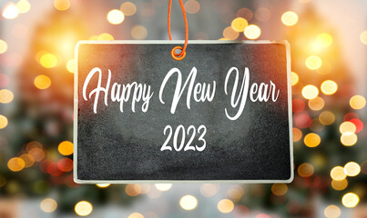 happy new year 2023 concept on handing chalkboard with blur bokeh background