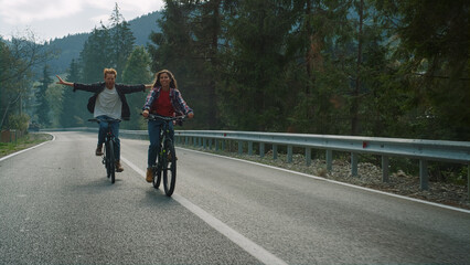 Fototapeta premium Lovers cycling mountain bikes on nature road. Happy couple enjoy sport activity.