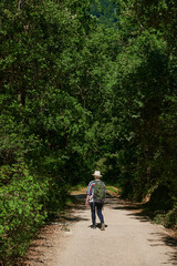 Middle-aged woman with hat and backpack doing the Santiago's way