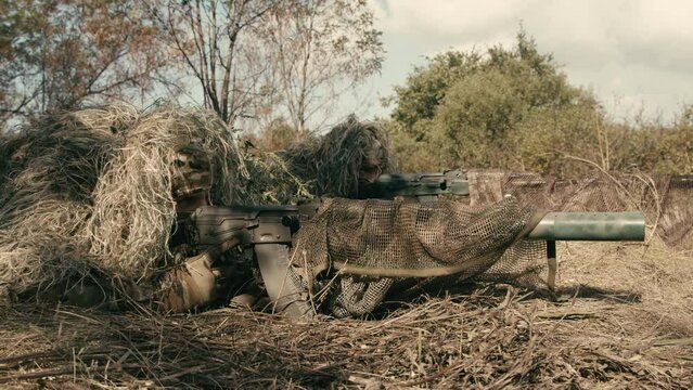 Special forces soldiers, snipers in camouflage clothes on anti-terrorist operation ready to shoot from sniper rifles, shooting at the enemy. Footage of military operations. War concept
