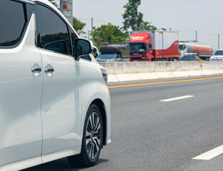 Part of a white a minivan driving on the highway