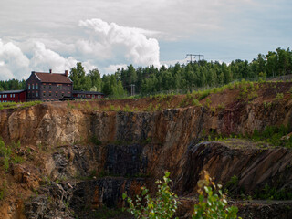 Naklejka premium Falun Copper Mine the World Heritage with orange mountain visible and tourist spot in background.