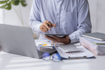 Businessman working at office with calculator documents on his desk, doing planning analyzing the financial report, business plan investment, finance analysis concept	