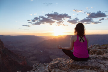 Adventurous Traveler woman doing meditation on Desert Rocky Mountain American Landscape. Cloudy Sunny Sky. Grand Canyon National Park, Arizona, United States. Adventure Travel