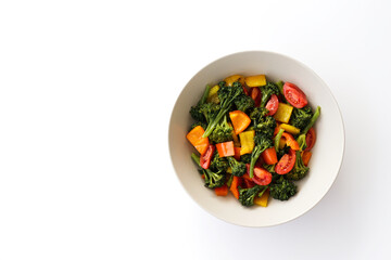 Tasty salad with steamed broccoli and fresh tomatoes in a white ceramic bowl. Clean eating concept. Healthy vegan dish made of organic vegetables. Close up, copy space, background.