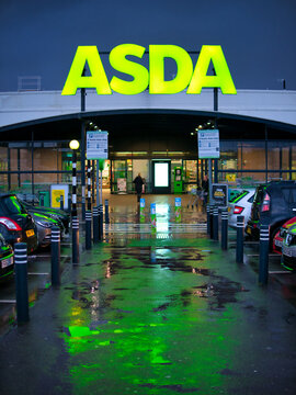 The car park and frontage of the a store of the ASDA British supermarket chain, located in a residential area in the North of England. Taken in portrait in late afternoon after rain.