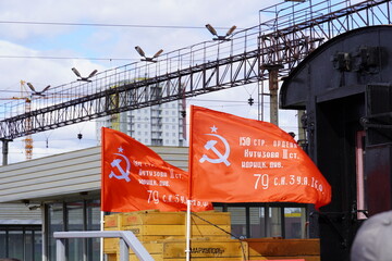 Two retro red flags waving in the wind with the symbols of the Soviet Union
