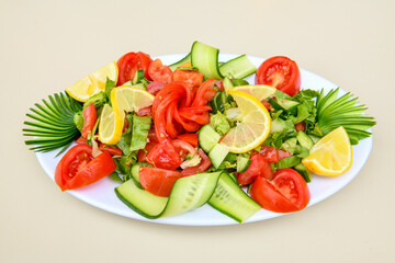 Green salad with arugula, lamb and tomatoes. Healthy vegan dish. Top view at table. Turkish Coban (choban) salata or Shepherds salad, Akdeniz salad in white bowl.