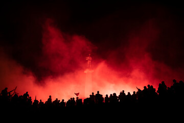 Fototapeta na wymiar Red Star Football fans with torches and flags celebrating league title win next to monument Pobednik in Belgrade, Serbia 22.05.2022
