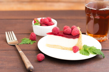 Raspberry pie ,cheesecake, made from fresh raspberries with tea on a wooden background.