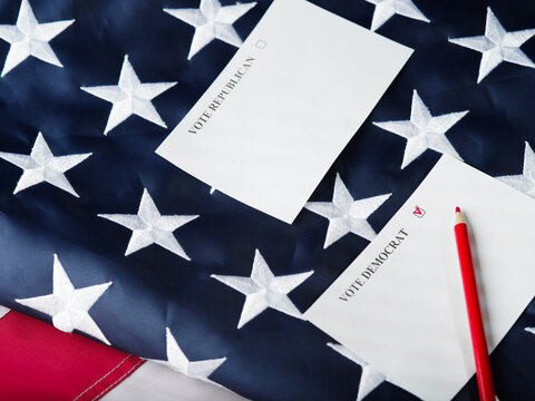 Against the background of the state American flag, two pieces of paper with a call to vote for Republicans or Democrats, a red pencil. Parliamentary elections, voting, poll. Banner, advertising.