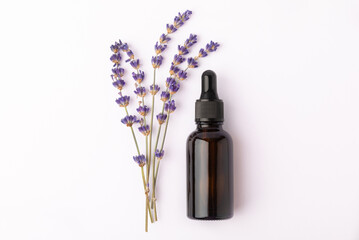 Lavender essential oil in glass bottle with pipette.Bottle with fragrant oil and lavender flowers isolated on white background.mockup of lavender essential oil with copy space.serum.