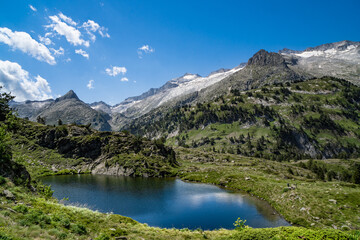 Obraz na płótnie Canvas Spectacular, wonderful and evocative landscape of a lake in the Pyrenees surrounded by mountains and snow-capped peaks of Benasque. In HDR color.