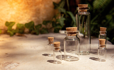 Obraz na płótnie Canvas Set of empty glass miniature bottles with cork cap on a natural background. Modern apothecary concept