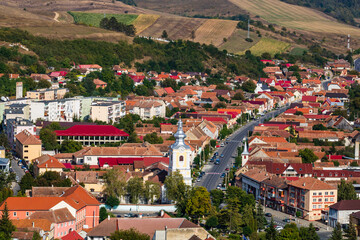 Fototapeta na wymiar Aerial view of the town center with hills, buildings, streets, vegetation and surroundings in Rupea, Romania, 2021