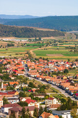 Fototapeta na wymiar Aerial view of the town center with hills, buildings, streets, vegetation and surroundings in Rupea, Romania, 2021