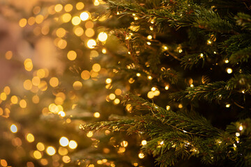 christmas tree with a garland of lights on a blurred background