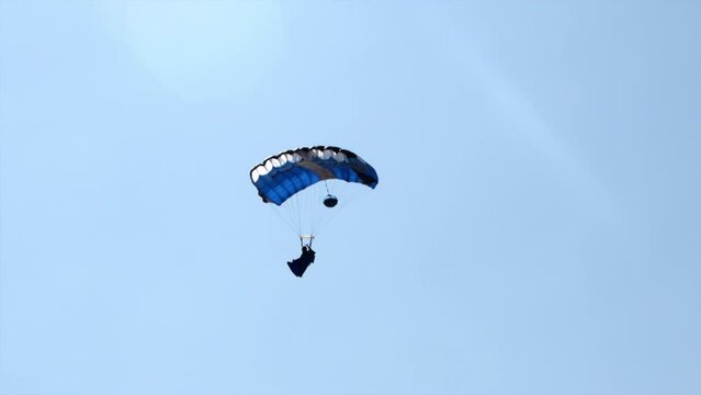 Panning A Parachutist Jumpsuit Pilot Soaring Through The Sky On A Deployed Parachute - Panama City, Panama