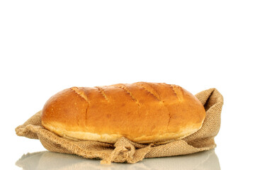 One fragrant fresh loaf with a jute bag, close-up, isolated on a white background.