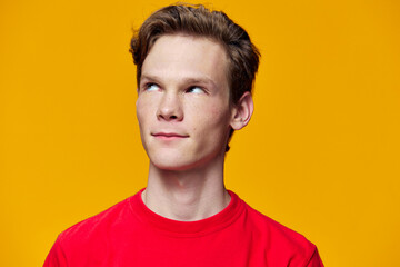 portrait of a cute guy looking away on a yellow background