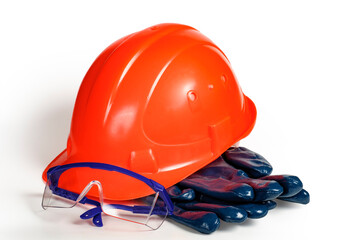 Worker's personal protective equipment set: helmet, goggles, gloves on white background.
