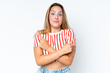 Young caucasian woman isolated on white background pointing to the laterals having doubts