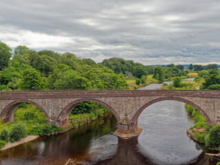 Fototapeta na wymiar The Lower North Water Bridge on the Road to St Cyrus in Aberdeenshire on a Summers evening with low clouds above.