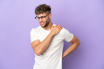 Delivery caucasian man isolated on purple background suffering from pain in shoulder for having made an effort