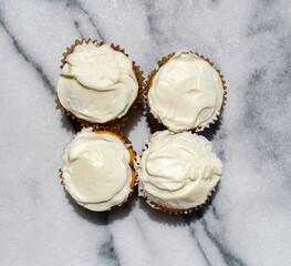 four cupcakes with vanilla icing 