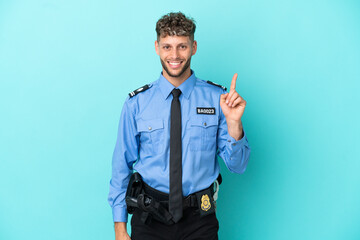 Young police blonde man isolated white on blue background showing and lifting a finger in sign of the best