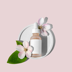 Fototapeta na wymiar A glass dropper bottle with a pipette on a round flat podium and flowers next to it on a pink background. Organic spa cosmetics.