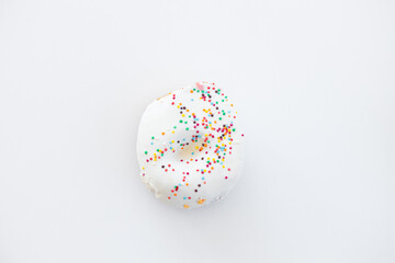 Fototapeta na wymiar Donuts decorated with colorful sprinkles isolated on white background. Flat lay. Top view