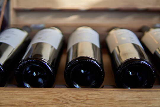 Opened wooden wine box packed with red wine and label. Selective focus. Visit to a winery