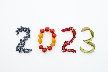 New year 2023 made of fruits on the white background. Healthy food
