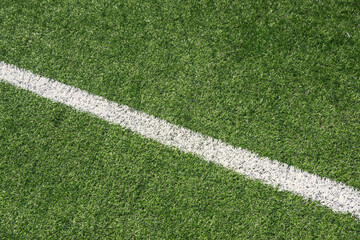Green synthetic artificial grass soccer sports field with white line