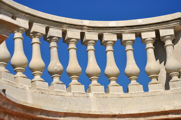 White railings with decorative balusters against a blue sky.  Architectural elements.