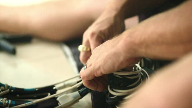 Close-Up Of A Man Adjusting And Winding The Cords Of A Parachute - Panama City, Panama