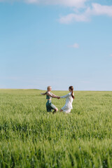 Naklejka premium Two Beautiful posing woman in the green field. Fashion, style concept.