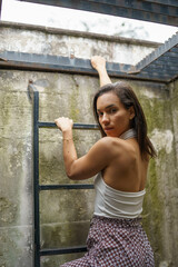 climbing the stairs of a basement a beautiful young brunette woman with short hair in the daytime, lifestyle