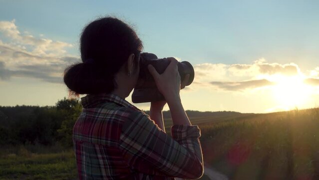 A young woman photographs the sun at sunset. The girl is filming the sunset. Camera movement. The concept of happiness, hobby, relaxation.