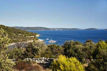 Coast of the Croatian sea with deep blue water. The yacht is moored near the shore