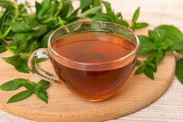 Cup of mint tea on table background. Green tea with fresh mint top view with copy space