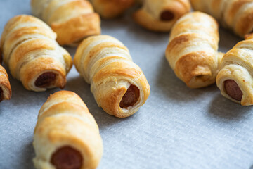 Pigs in a blanket - mini rolls with sausages wrapped in a puff pastry dough. - 521523581