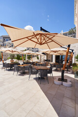 Cozy outdoor restaurant with sun umbrellas without people in Montenegro