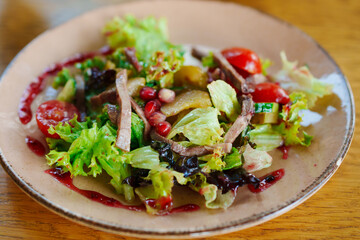 plate with salad with meat, vegetables and red sauce. 