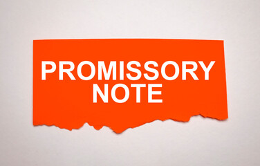 The text Promissory Note appearing behind torn red paper